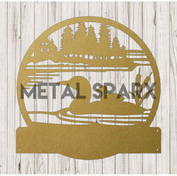 Gold metal art of a loon with a baby, featuring a monogram design by Metal Sparx, displayed as decorative wall decor.